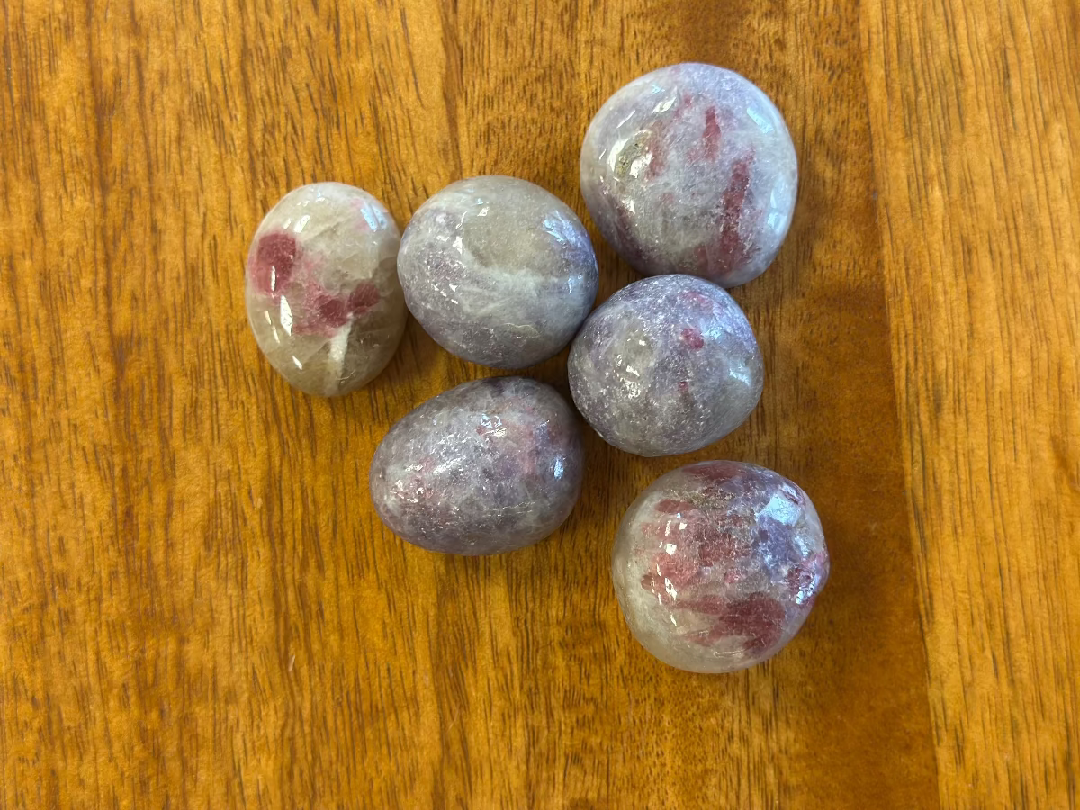 Rodado de mineral de turmalina rosa sobre eudialita